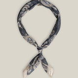 Navy cotton bandana with intricate light paisley motifs and a pale contrasting border, tied as a neck scarf.