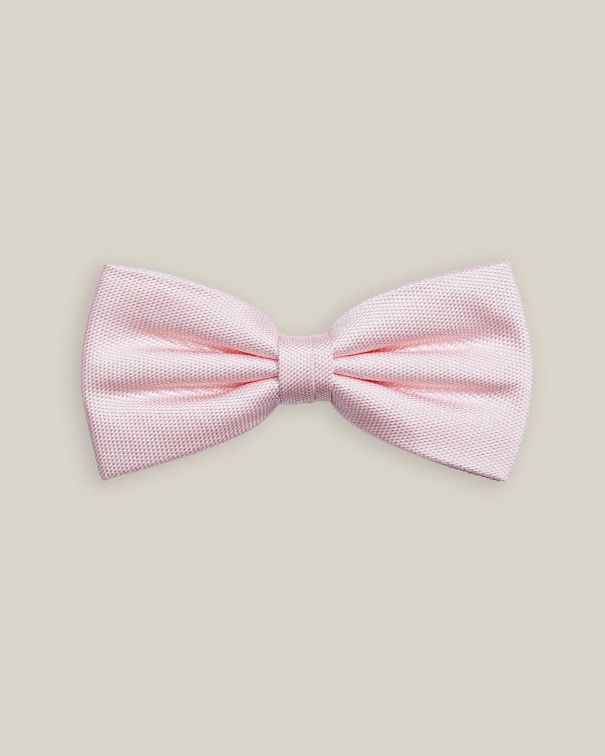 Soft pink pre-tied bow tie with a finely textured woven silk finish