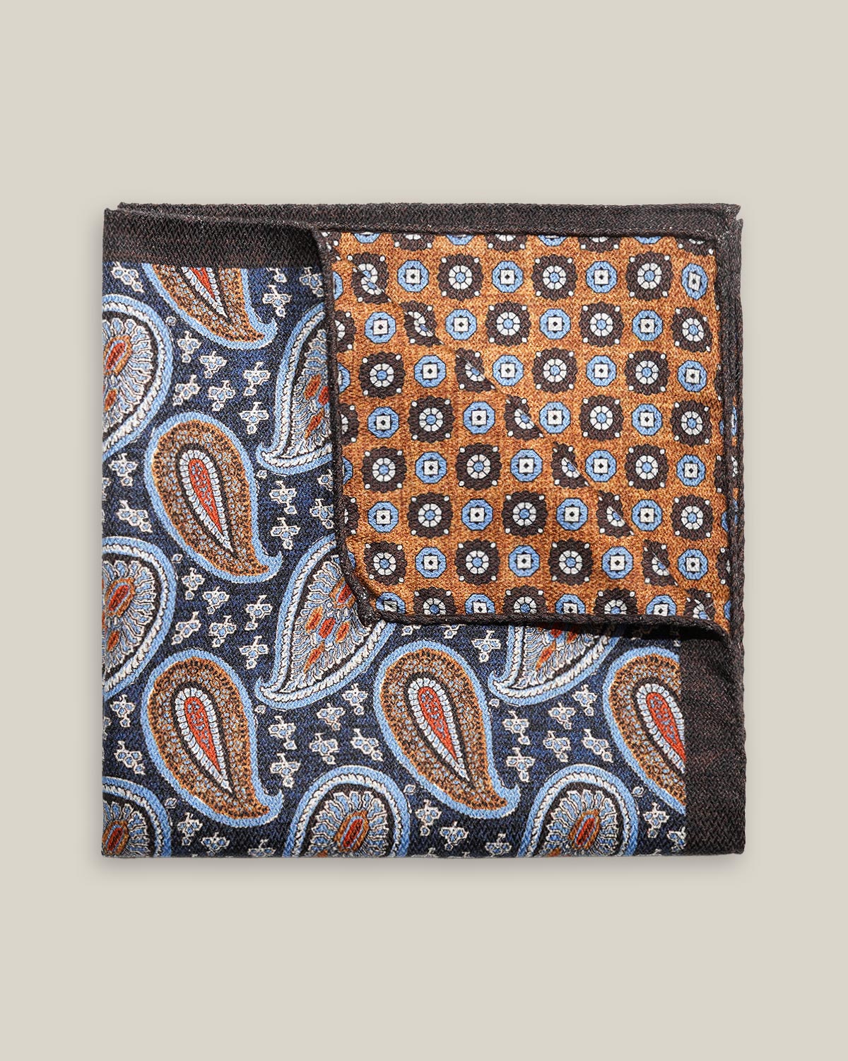 Double-face silk pocket square with deep blue paisley and a copper geometric floral reverse, featuring pale blue, brown, red and ivory details.