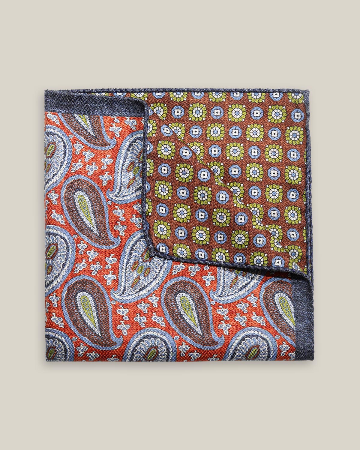 Double-face silk pocket square with rust-red paisley and a brown geometric floral reverse in blue-grey, olive green and ivory.