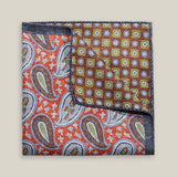 Double-face silk pocket square with rust-red paisley and a brown geometric floral reverse in blue-grey, olive green and ivory.