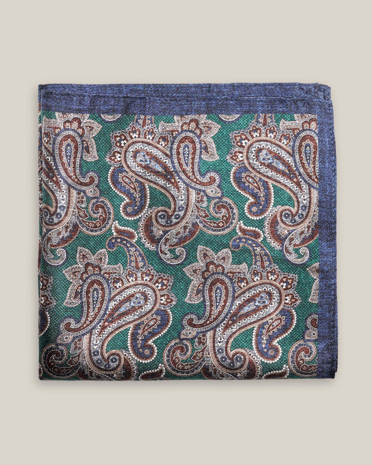 Green printed silk pocket square with large brown, ivory and muted blue paisley motifs and a contrasting navy border.