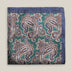 Green printed silk pocket square with large brown, ivory and muted blue paisley motifs and a contrasting navy border.