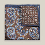 Brown double-face silk pocket square with ornate pale blue, navy, ochre and ivory paisley, a small floral medallion reverse and a navy border.