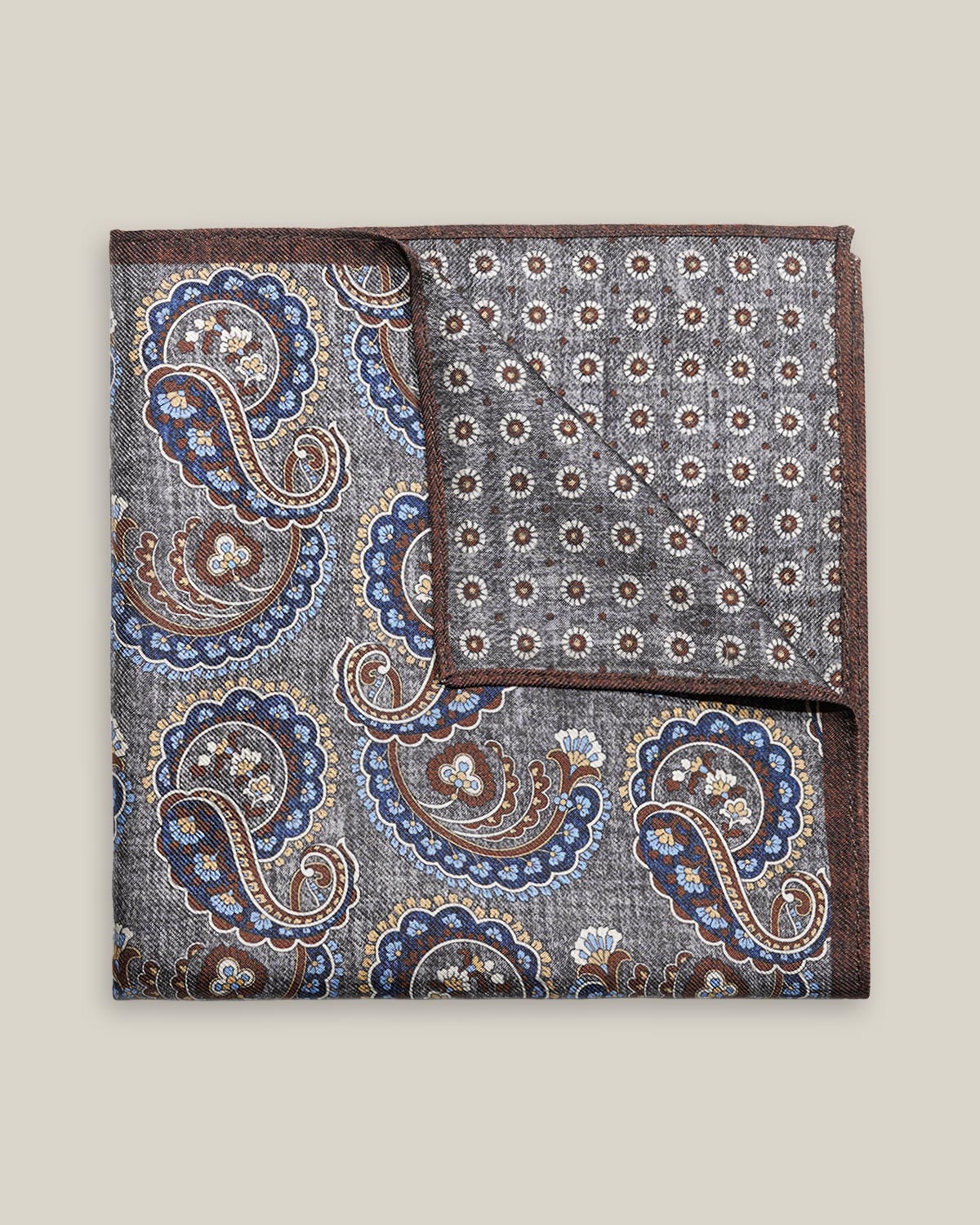 Grey double-face silk pocket square with ornate navy, pale blue, brown and ivory paisley, a small floral medallion reverse and a brown border.