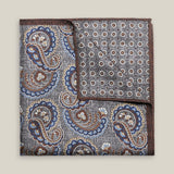 Grey double-face silk pocket square with ornate navy, pale blue, brown and ivory paisley, a small floral medallion reverse and a brown border.