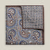 Grey double-face silk pocket square with ornate navy, pale blue, brown and ivory paisley, a small floral medallion reverse and a brown border.