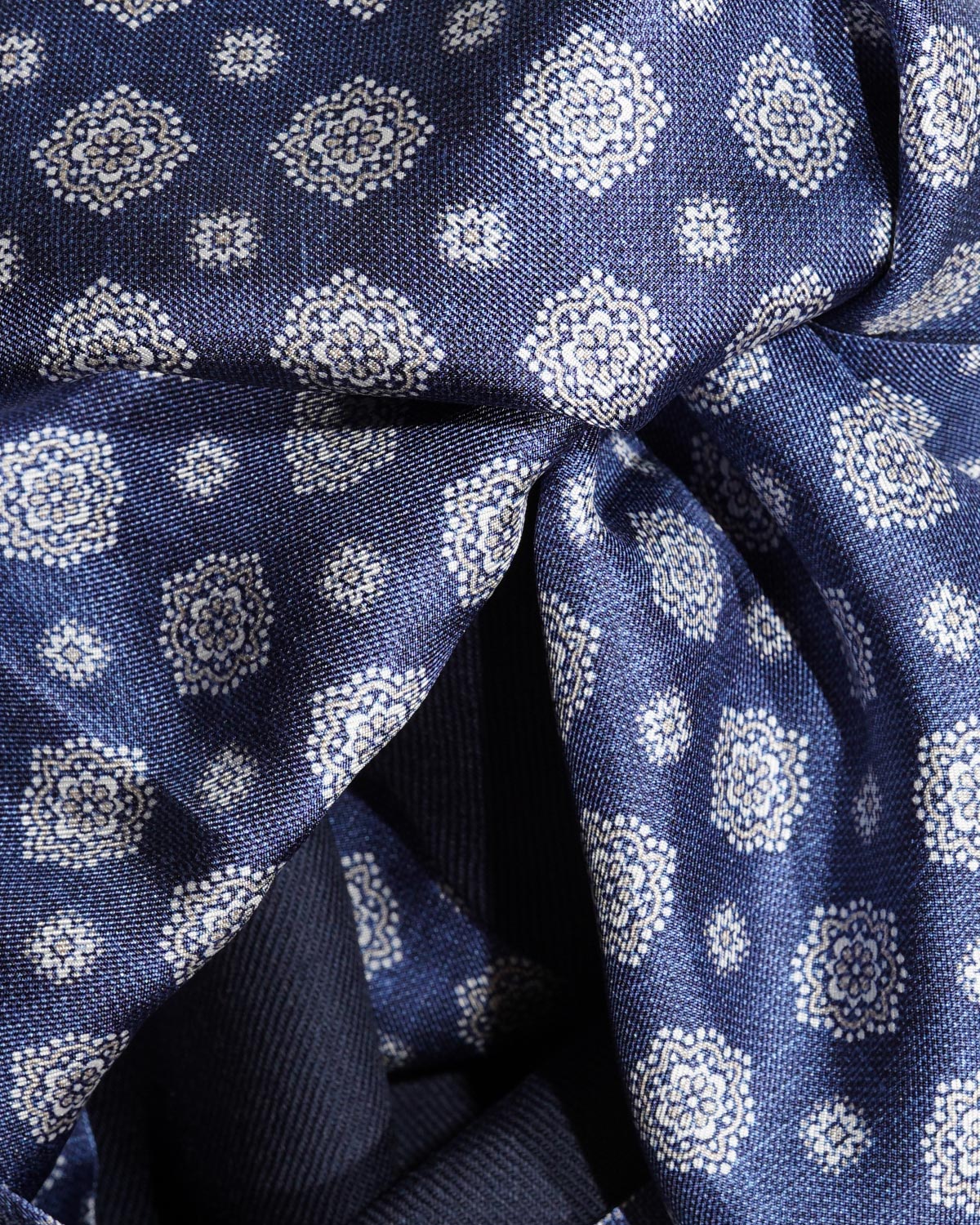 Close-up of the navy silk scarf with ivory floral medallions and smaller decorative motifs
