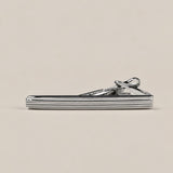Silver-tone tie clip with fine horizontal grooves and a spring-loaded fastening.