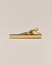Shiny gold-tone tie clip with a smooth straight front and spring-loaded fastening.