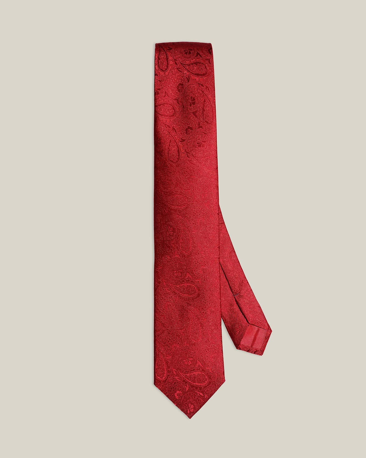 Red paisley silk tie rolled, showing tonal paisley weave detail, by Stockholm Kravatt