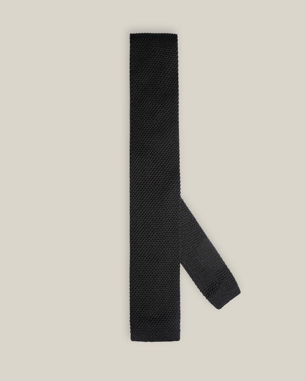 Black knitted tie with a textured surface and classic straight square end