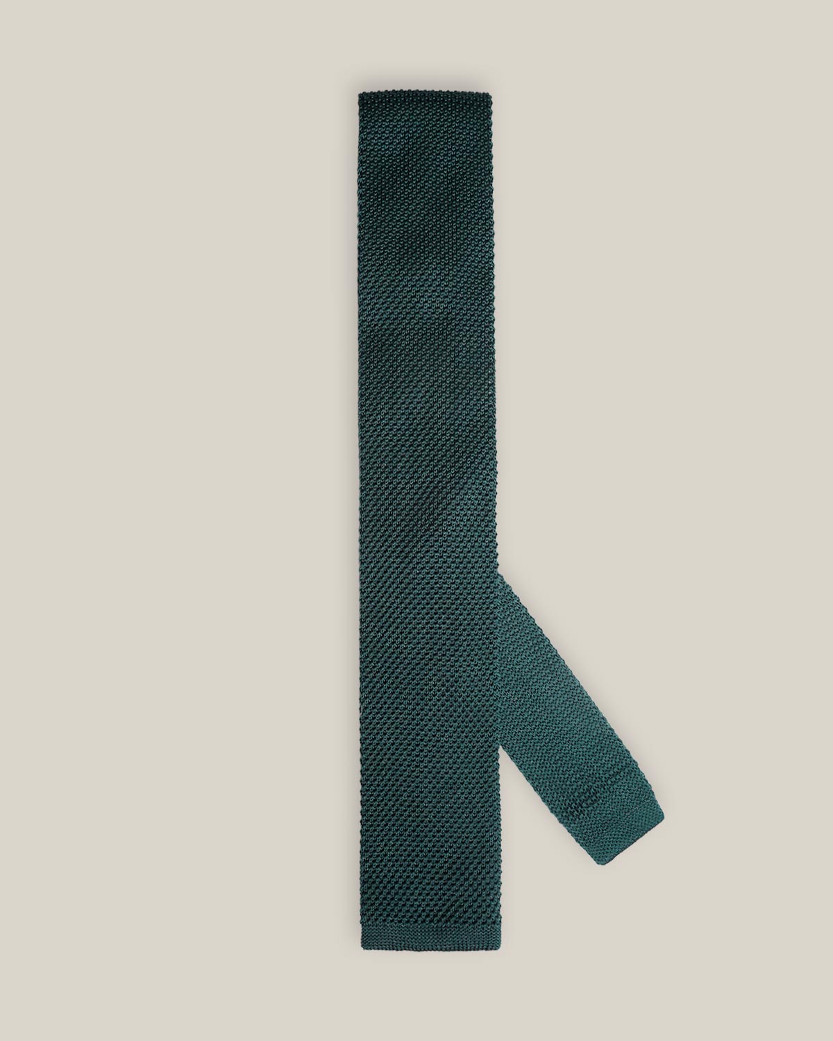 Deep green knitted tie with a textured surface and classic straight square end