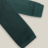 Deep green knitted tie with a textured surface and classic straight square end