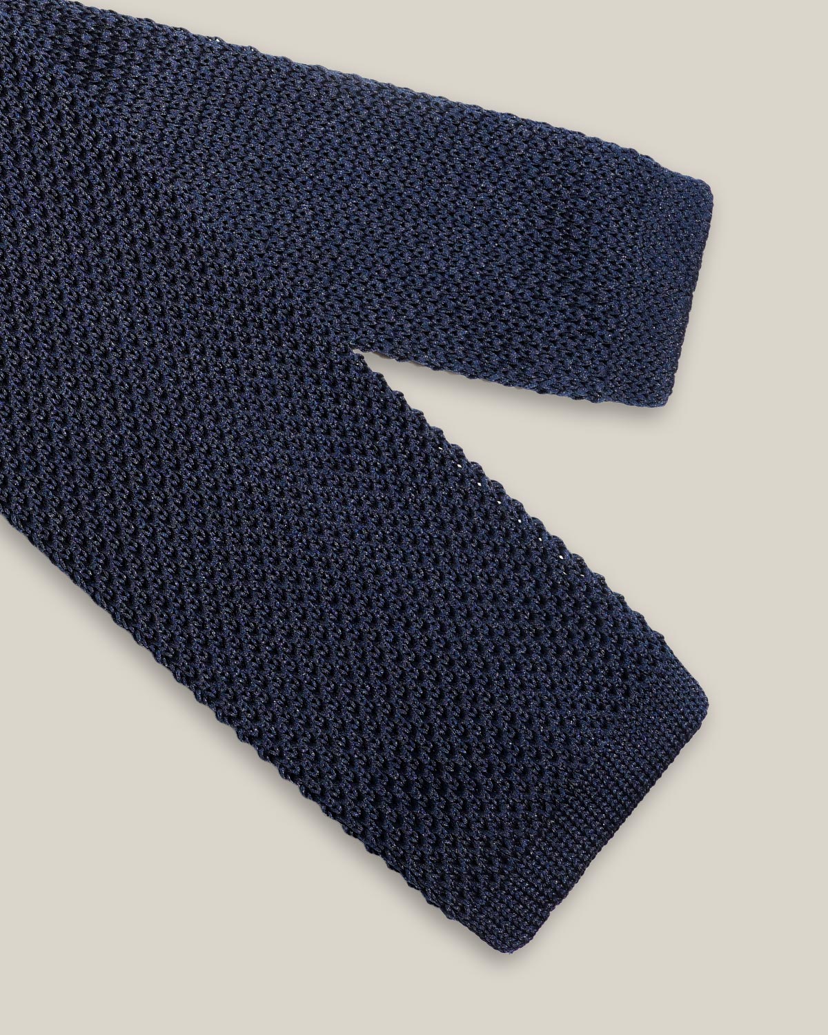 Navy knitted tie with a textured surface and classic straight square end