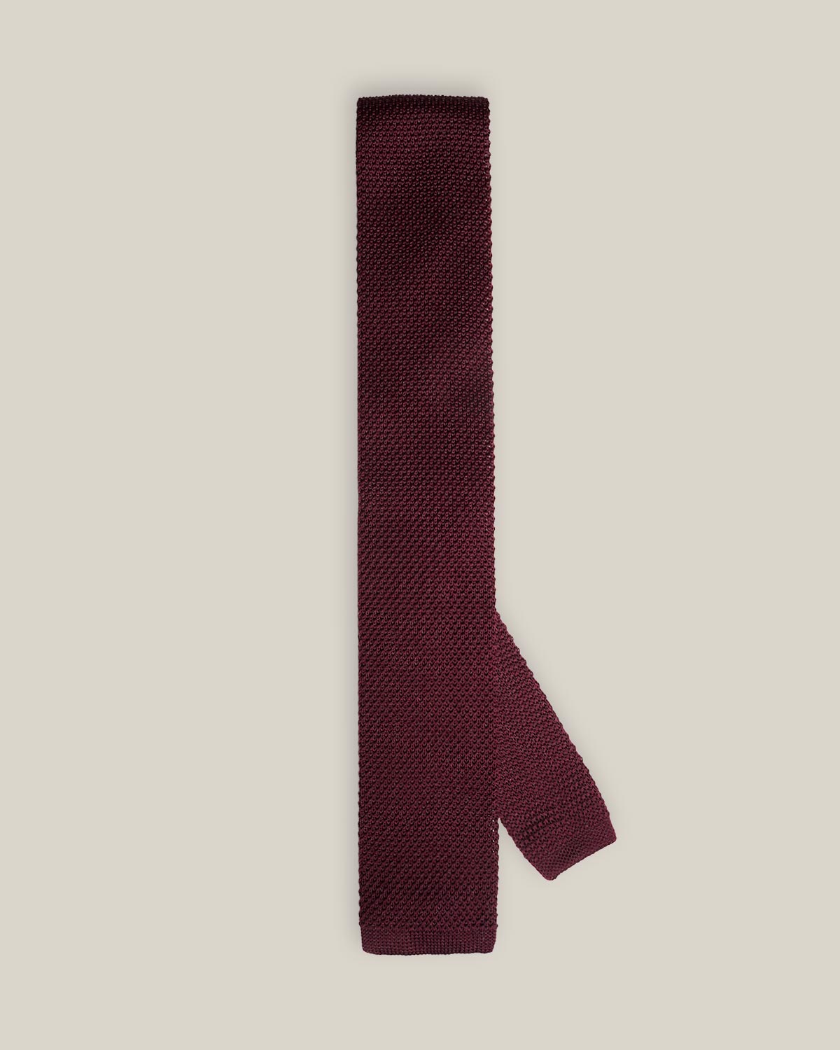 Burgundy knitted tie with a textured surface and classic straight square end