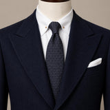 Navy micro-dot silk tie styled on a mannequin with navy suit and white shirt by Stockholm Kravatt