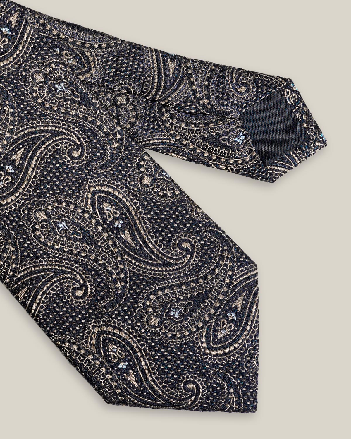 Navy blue woven silk tie with an intricate all-over brown paisley pattern