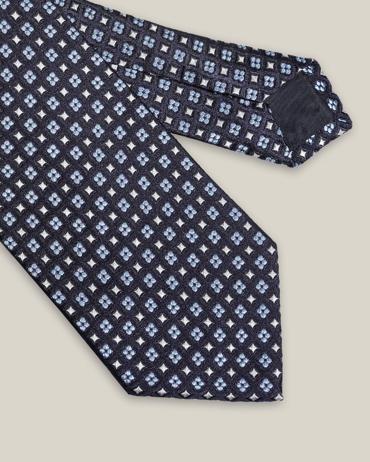 Navy woven silk tie with small light blue floral motifs by Stockholm Kravatt