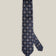 Navy woven silk tie with repeating light blue and silver-toned geometric medallions