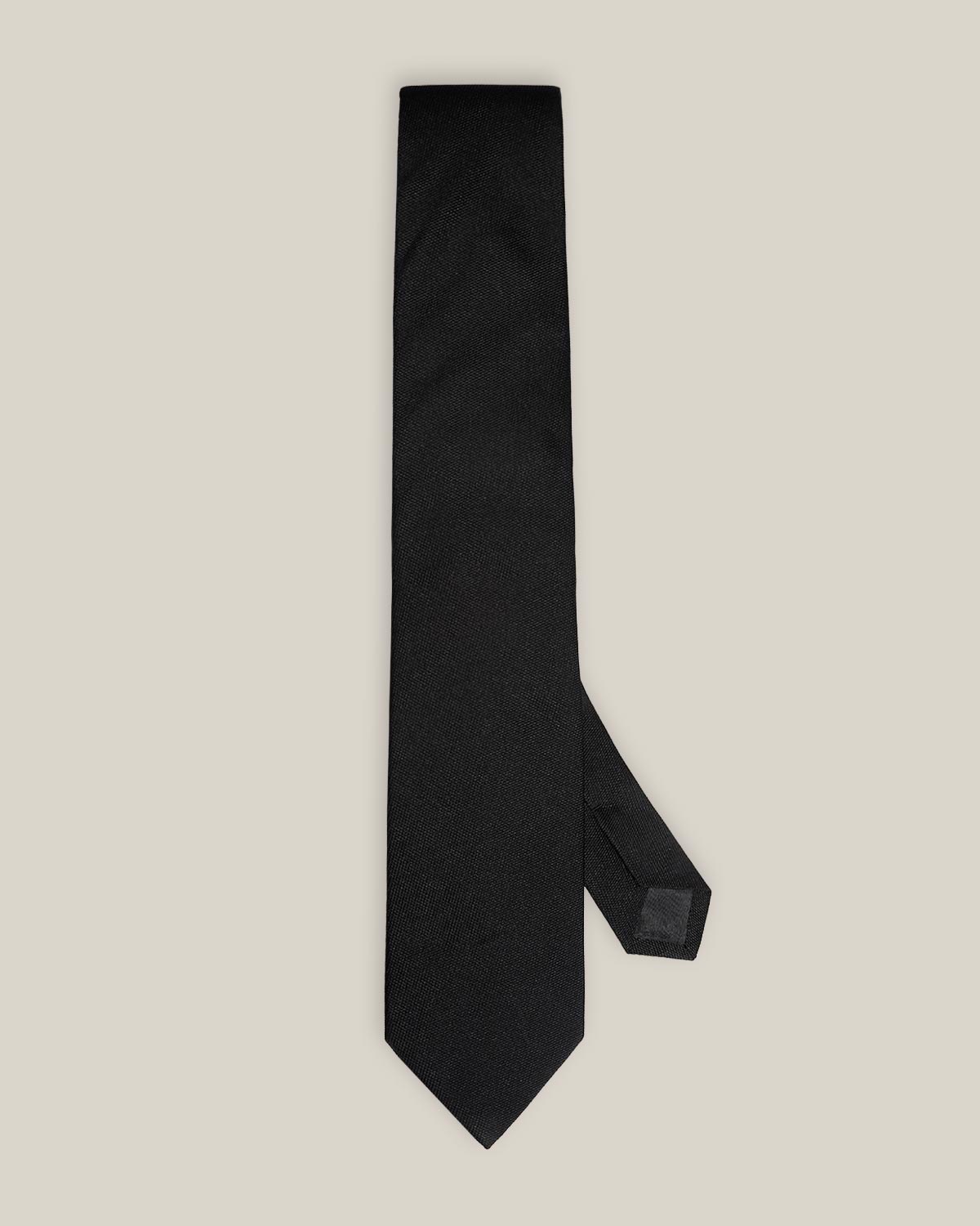 Classic black woven pure silk tie on a light background