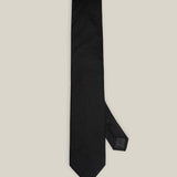 Classic black woven pure silk tie on a light background