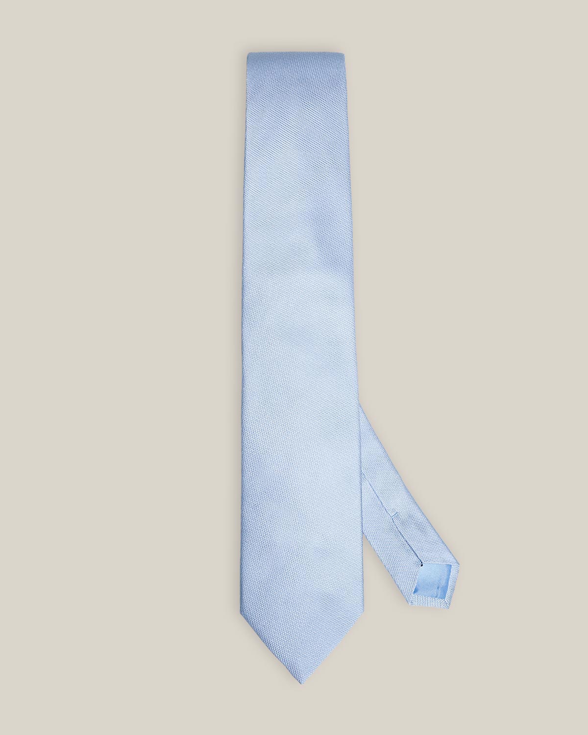 Light blue woven pure silk tie on a neutral background