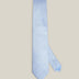 Light blue woven pure silk tie on a neutral background