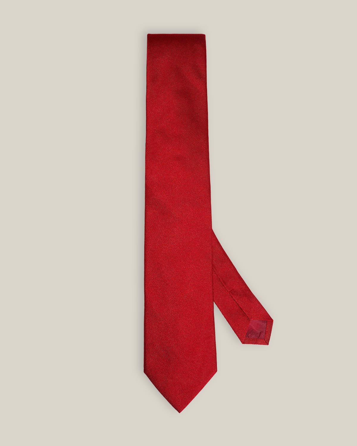 Bright red woven pure silk tie on a neutral background