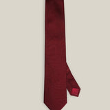 Burgundy woven pure silk tie on a neutral background