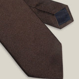 Brown woven pure silk tie on a neutral background
