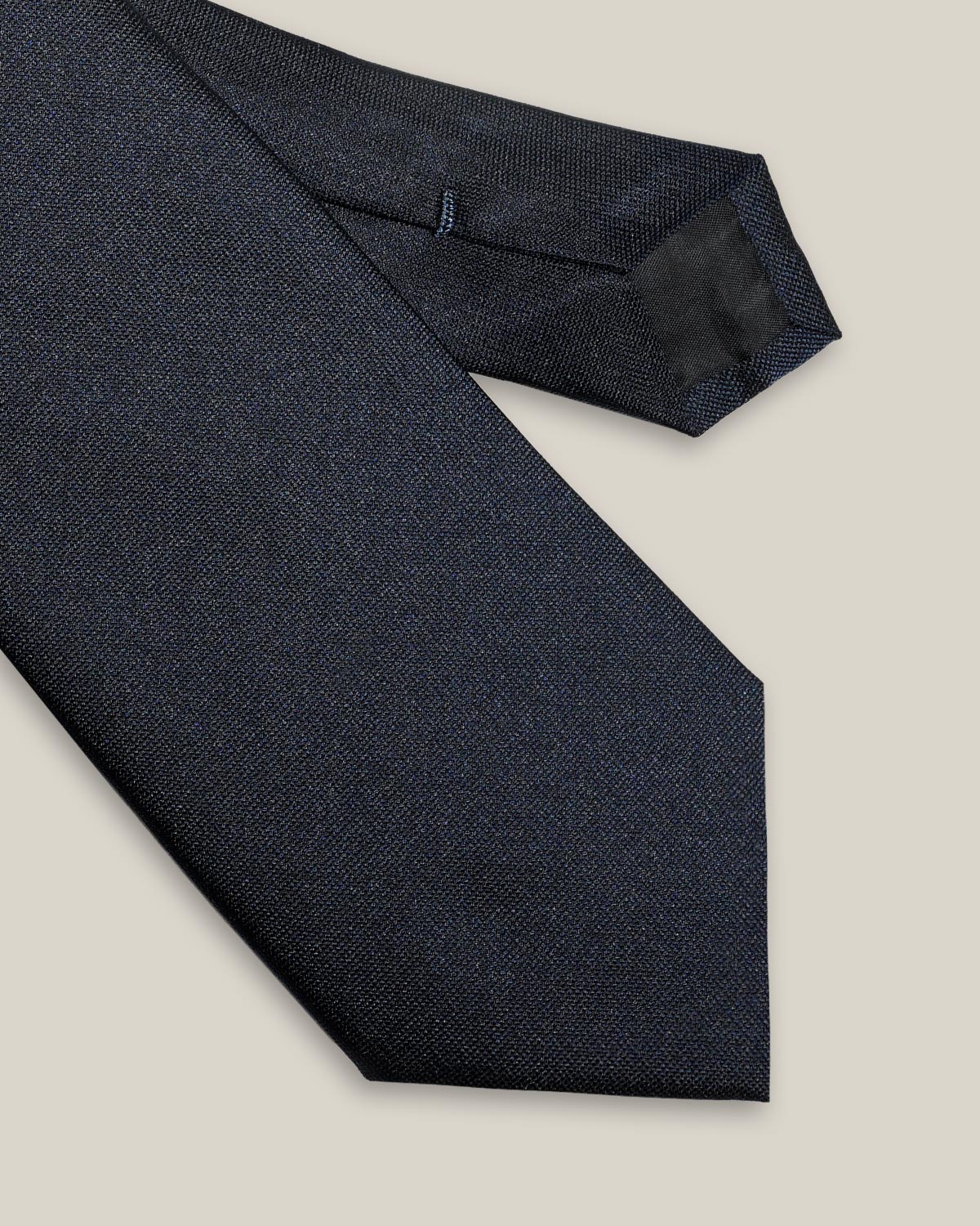 Close-up of navy blue silk tie showing its fine Oxford texture