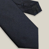 Close-up of navy blue silk tie showing its fine Oxford texture