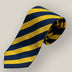 Navy and gold striped silk tie rolled up on neutral background