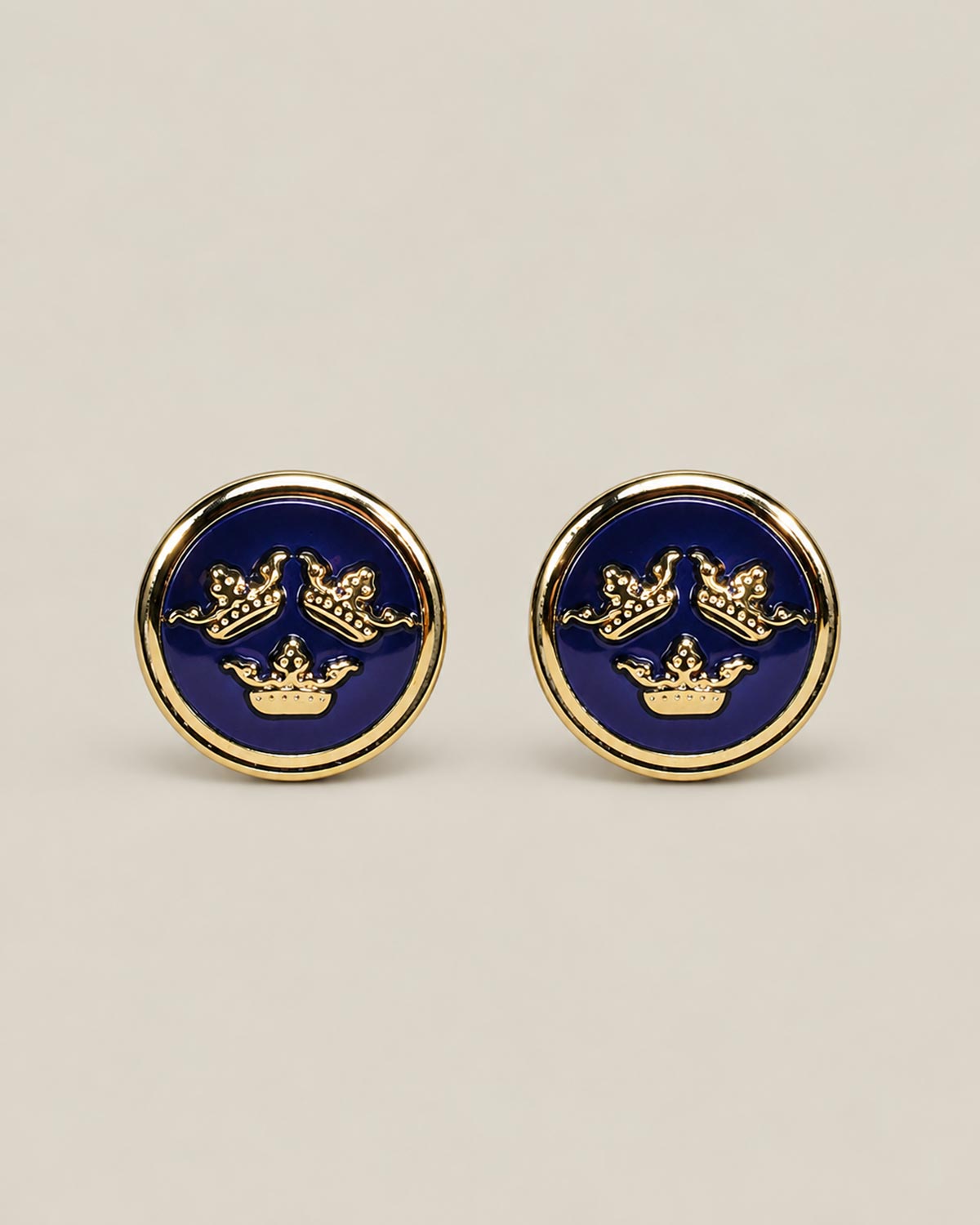 Round gold cufflinks with navy blue enamel face and three crowns motif