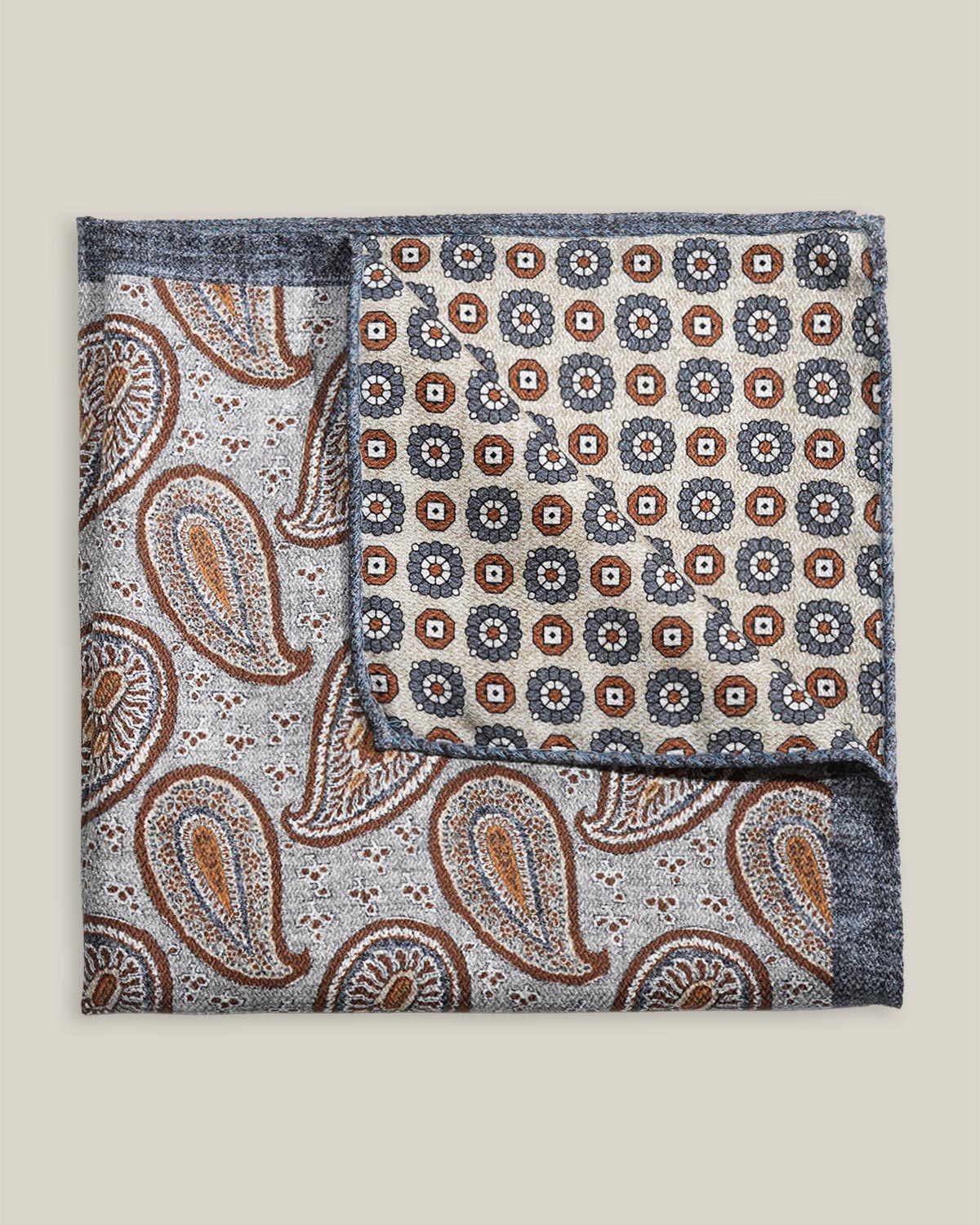 Two sides of a double-face silk pocket square with paisley and geometric patterns