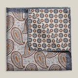 Two sides of a double-face silk pocket square with paisley and geometric patterns